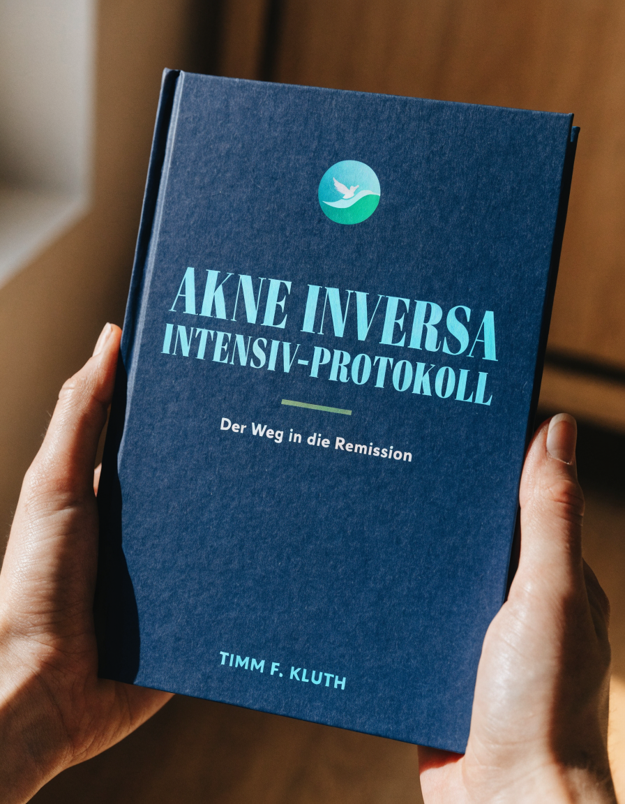 Zwei Hände halten das Buch: Akne Inversa Intensiv-Protokoll — Der Weg in die Remission, von Timm F. Kluth.